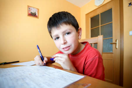 boy doing school homework from mathematics in workbook