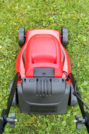  new lawnmower on green grass in cloudy dayの写真素材