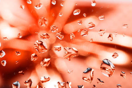 red abstract background with water drops on glass with ribbon in background の写真素材