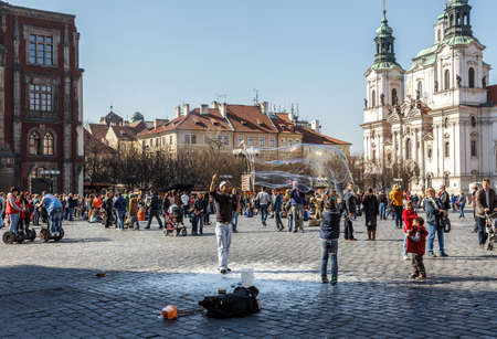 PRAGUE, CZECH REPUBLIC - MARCH 13th, 2014 - Street artist make bubles on Old Town Square in front of...