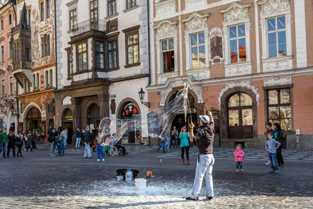 PRAGUE, CZECH REPUBLIC - MARCH 13th, 2014 - Street artist make bubles on Old Town Square in front of touristsのeditorial素材