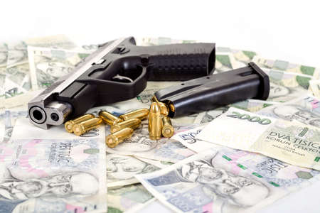 detail of gun with bullet on czech banknotes background