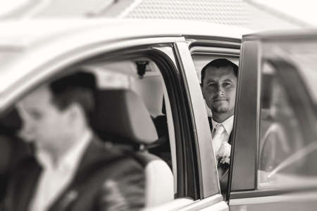groom sitting in a car, monochrome toned photoの写真素材