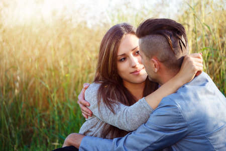 Happy smiling young couple embracing outdoor at sunny dayの写真素材
