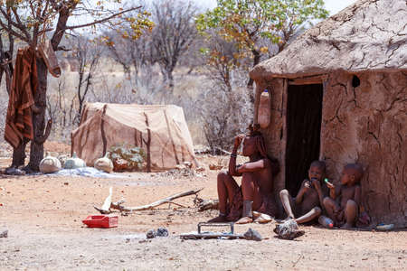 NAMIBIA, KAMANJAB, OCTOBER 10: Himba tribe woman with childs, in the village of Himba people near Kamanjab in northern Namibia, August 10, 2014, Namibiaのeditorial素材