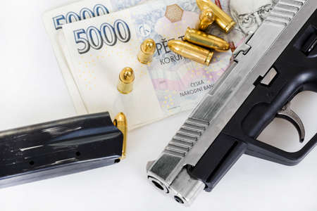 detail of gun with bullet on czech banknotes background