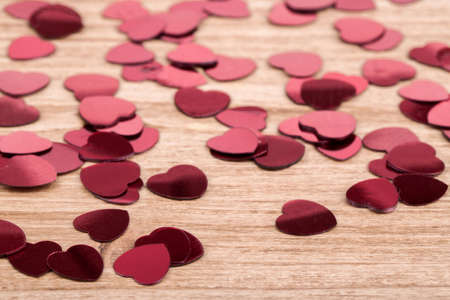 small red hearts confetti on wooden background, calentine love conceptの写真素材