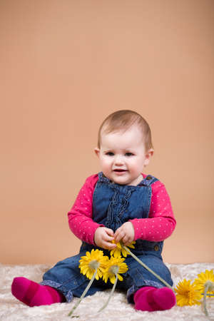 smiling infant baby with yellow flowers - the first year of the new life