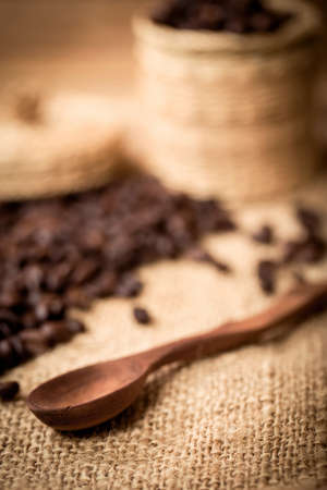 pile of coffee beans and wooden spoon with space for text, focus to spoon with shallow focusの写真素材