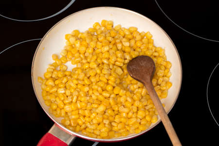 macro of cooking sweet conn with wooden spoon