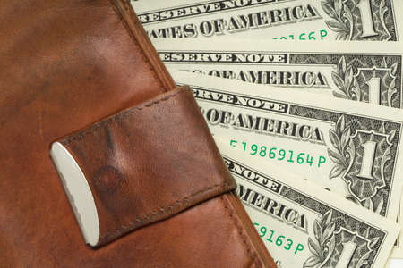 leather wallet with money banknotes US dolars nominal value one, five, ten and twenty isolated on whiteの写真素材