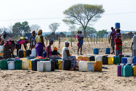 NAMIBIA, KAVANGO, OCTOBER 15: Unidentified Namibian woman with child near public tank with drinking water.Kavango region. October 15, 2014, Namibiaのeditorial素材
