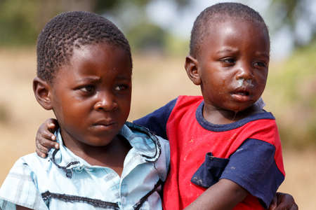 NAMIBIA, KAVANGO, OCTOBER 15: Unidentified Namibian boy carries his small brother in her arms. Kavango region near Rundu. October 15, 2014, Namibiaのeditorial素材