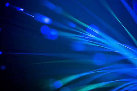 bunch of optical fibres flying from deep as blurred abstract technology backgroundの写真素材
