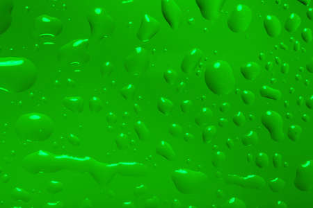 green abstract background with water drops on glass for background or backdropの写真素材