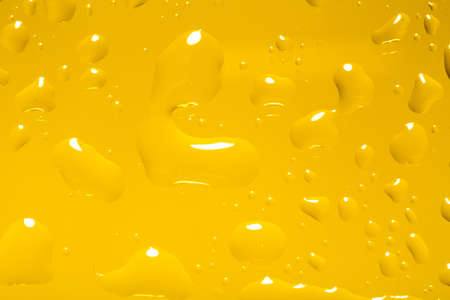 yellow abstract background with water drops on glass for background or backdropの写真素材