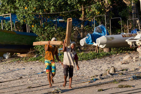 BALI, NUSA PENIDA ISLAND, INDONESIA - JULY 27.2015: Men transports cargo from ship to the shipyard...