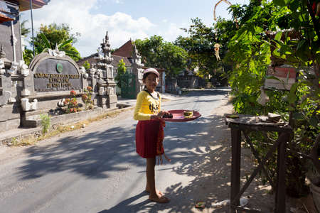 BALI, NUSA PENIDA ISLAND, INDONESIA - JULY 28.2015: Unidentified balinese indonesian girl bring offerings of fruits and gifts to the home temple. Nusa Penida July 27. 2015 Indonesiaのeditorial素材