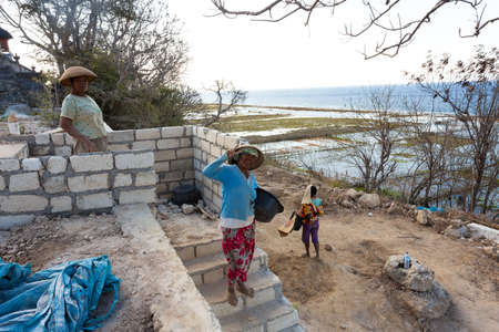 BALI, NUSA PENIDA ISLAND, INDONESIA - JULY 28.2015: Unidentified balinese indonesian woman with basket with seaweed. Nusa Penida July 27. 2015 Indonesiaのeditorial素材