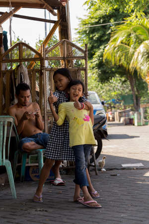 MANADO, NORTH SULAWESI, INDONESIA - AUGUST 5, 2015: Indonesian girls with family in Manado shantytown on August 5, 2015 in Manado, North Sulawesi, Indonesiaのeditorial素材
