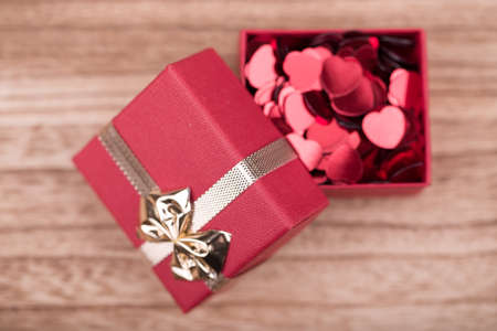 small red hearts confetti and present box on wooden backgroundの写真素材