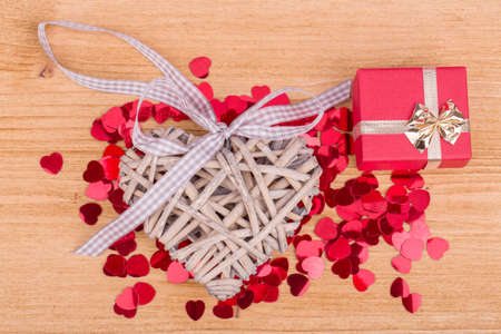 small red hearts confetti and present box on wooden backgroundの写真素材
