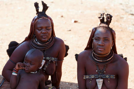 NAMIBIA, KAMANJAB, OCTOBER 10: Himba tribe woman with child, in the village of Himba people near...