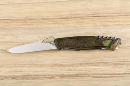 Multipurpose knife on wooden background with all neccessary tools all in one