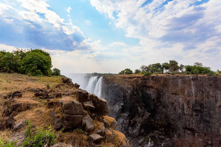 The Victoria falls is the largest curtain of water in the world (1708 meters wide). The falls and the surrounding area is the National Parks- Zambia, Zimbabweの写真素材