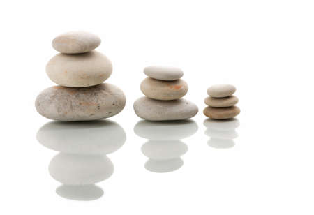 Pile of balancing pebble stones, like ZEN stone, isolated on white background, spa tranquil scene concept with reflectionの写真素材