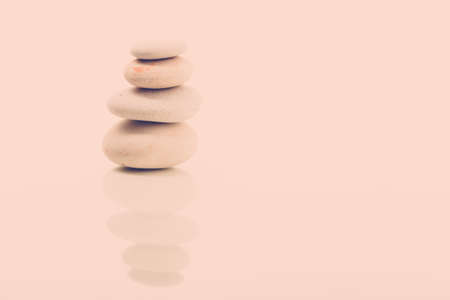 Pile of balancing pebble stones, like ZEN stone, isolated on white background, spa tranquil scene concept with reflection, retro color pastel toneの写真素材