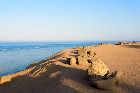 red sea in Egypt coastline with sand and stones. Tranquil scene with blue water and skyの写真素材