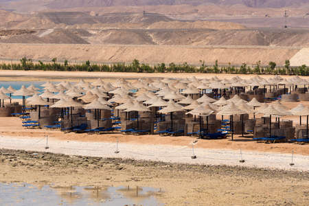 Beach umbrellas on sandy egypt beach. Sea in low tide. holiday summer vacation concept. No People.の写真素材