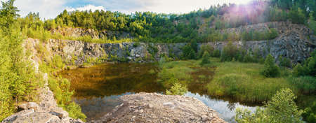 panorama of abandoned and flooded quarry, Czech Republic, teal and orange color tone. Beautiful...