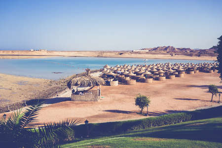 Beach umbrellas and blue sky background in egypt paradise beach. holiday summer vacation concept. No People. REtro color toneの写真素材