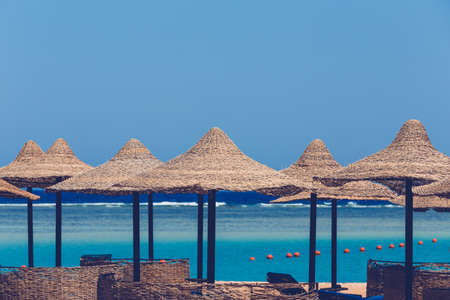Beach umbrellas and blue sky background in egypt paradise beach. holiday summer vacation concept. No People. REtro color toneの写真素材
