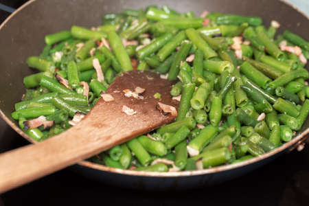 home roasting fresh green beans with bacon and spices on pan as dish to meatの写真素材