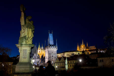 Night photo of Prague Charles Bridge and powder tower view from bridge, long exposure, people in motion blur Bohemia, Czech Republicの写真素材