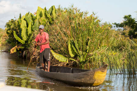 MADAGASCAR OCTOBER 18.2016 Malagasy countryside people from village transport freight by Traditional handmade dugout wooden boat. Everyday life on the river. Maroantsetra October 18. 2016, Madagascar.のeditorial素材
