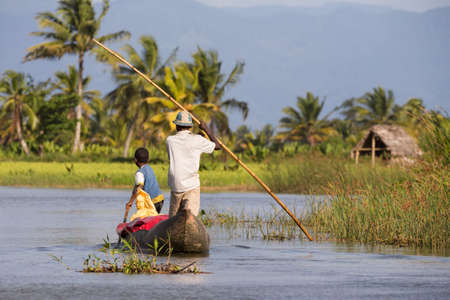 MADAGASCAR OCTOBER 18.2016 Malagasy countryside people from village transport freight by Traditional handmade dugout wooden boat. Everyday life on the river. Maroantsetra October 18. 2016, Madagascar.のeditorial素材