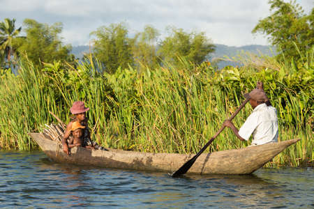 MADAGASCAR OCTOBER 18.2016 Malagasy countryside people from village transport freight by Traditional handmade dugout wooden boat. Everyday life on the river. Maroantsetra October 18. 2016, Madagascar.のeditorial素材