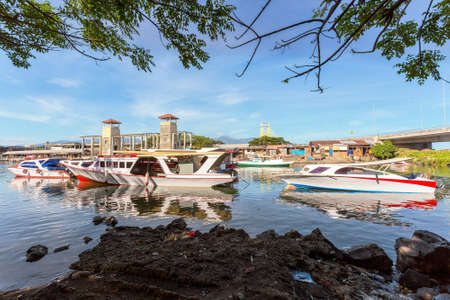 poor houses with sheet tin by the river with boats on the river,Kota Manado, North Sulawesi, Indonesiaの写真素材
