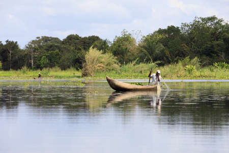 MADAGASCAR OCTOBER 20.2016 Malagasy countryside people from village fishing on river with traditional handmade dugout wooden boat. Everyday life on river. Maroantsetra October 20. 2016, Madagascar.のeditorial素材