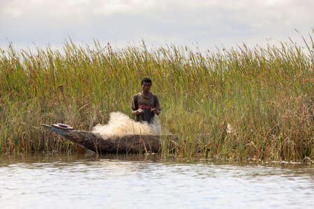 MADAGASCAR OCTOBER 19.2016 Malagasy countryside people from village fishing on river with traditional handmade dugout wooden boat. Everyday life on river. Maroantsetra October 19. 2016, Madagascar.のeditorial素材