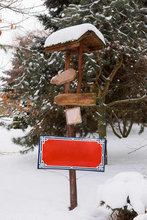 wooden empty signpost in winter garden with fresh snowの写真素材