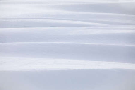 Winter snowdrift background with beautiful lines and shadowsの写真素材