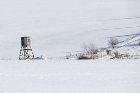 scenery with frozen european highland landscape in winter with hunting tower in sunny dayの写真素材