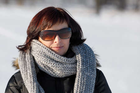 portrait of happy smiling middle age woman without makeup in winter time with sunglasses