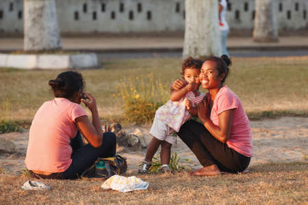 TOAMASINA, MADAGASCAR OCTOBER 17.2016: Malagasy beauties, woman with child resting in central park in the second largest city of Madagascar. In October 17. 2016, Toamasina, Madagascarのeditorial素材