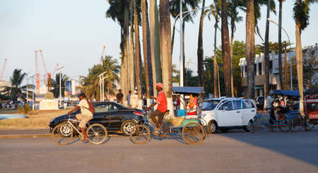 TOAMASINA, MADAGASCAR - OCTOBER 17, 2016: Traditional rickshaw bicycle with malagasy peoples in Madagascar second largest city Toamasina. Ordinary street life in Toamasina, Madagascar October 17. 2016のeditorial素材